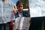 أحد أبناء المختطفين في اليوم العالمي يرفع لوحة كتب عليها اريد بابا